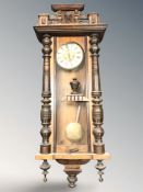 An early 20th century walnut and beech Vienna style eight day wall clock, with pendulum,