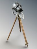A chrome theatre light on brass mounted teak tripod, height 119 cm.