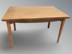 A Danish teak pull out extending dining table, overall 232 cm L x 80 cm W x 74 cm H.