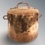 A copper twin handled cooking pot with lid, height 35 cm.