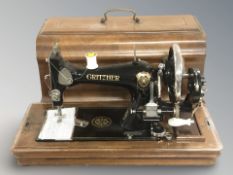 A Gritzner sewing machine in walnut box.