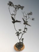 A modern wrought metal sculpture depicting birds amongst foliage,