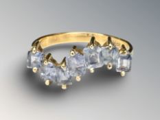 An 18ct yellow gold ring set with seven pale blue gemstones,