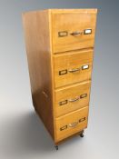 A vintage teak and plywood four drawer pedestal cabinet from a haberdashery,