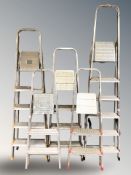 Five various aluminium step ladders.