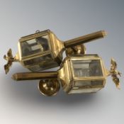 A pair of brass carriage style light fixtures surmounted by eagles, height 36 cm.
