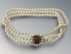 A fine triple strand of pearls with yellow gold clasp set with amethyst,