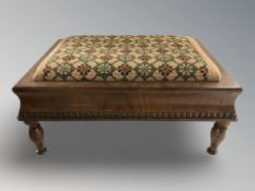 An early 20th century mahogany needlepoint footstool, width 38 cm.