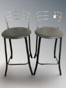 A pair of modern metal and black vinyl bar stool chairs
