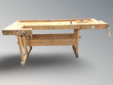 A large 20th century pine workbench fitted with two vices, 220 cm L x 96 cm D x 83 cm H.