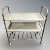 A metal three tier trolley on castors,