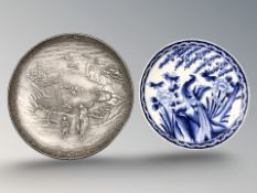 A Japanese embossed pewter circular dish depicting a woman and child in a landscape, diameter 25 cm,
