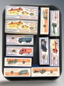 A group of reproduction Dinky die cast scale delivery vans and haulage wagons, with boxes,