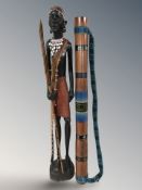 An African carved hardwood figure of a man, height 74 cm, and a rain making stick.