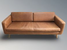 A contemporary Scandinavian stitched tan leather four seater settee, 202 cm x 93 cm x 70 cm.