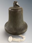 A patinated bronze bell, with clapper, height 31 cm.