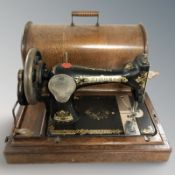A Singer hand sewing machine in oak case