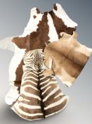 A group of animal skin rugs including a cow,