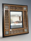 An early 20th century Islamic turned hardwood ebonised and mother of pearl inlaid wall mirror,