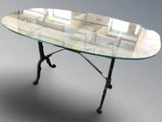 A wrought metal oval glass topped table, 130 cm x 70 cm x 70 cm.