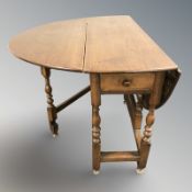 A 19th century elm drop leaf dining table,