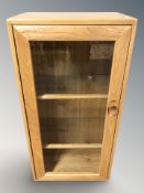 An Ercol light elm glazed door music cabinet, 47 cm x 33 cm x 92 cm.