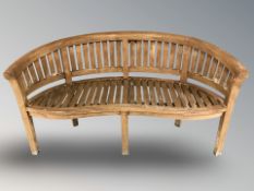 A curved teak garden bench,