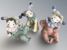 Three Nao figures of harlequin children.