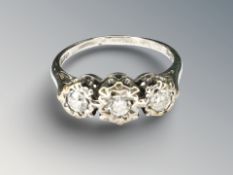 A 9ct white gold three-stone diamond ring, the stated diamond weight 0.25 carat, size L.