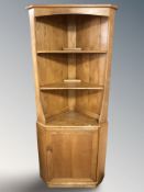An Ercol light elm standing corner cabinet, height 179 cm.