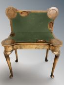 A Queen Anne style figured walnut turnover top card table on pad feet,