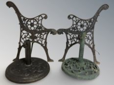 A pair of cast metal bench ends and two garden table parasol bases