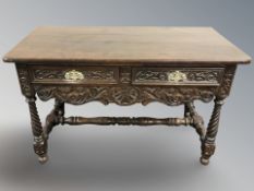 A heavily carved two drawer side table, 121 cm x 58 cm x 73 cm.