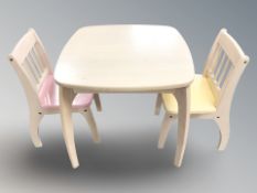A child's table, width 57 cm, and matching pair of chairs.