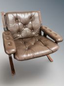 A Danish stained bentwood lounge armchair, upholstered in buttoned brown leather, width 79 cm.