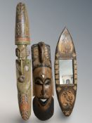 An Aborginial painted hardwood mask, length 100 cm, and a further pair of masks and a mirror.
