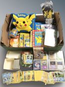 A collection of Pokemon cards, books, Pikachu box, mug and other collectibles.