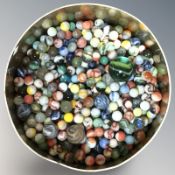 A tin containing a large quantity of marbles.