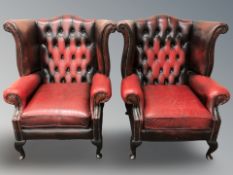 A pair of Chesterfield oxblood buttoned leather wingback armchairs, width 93 cm.
