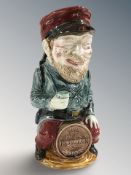 A French Majolica jug in the form of a legionnaire sat on a barrel, height 28 cm.