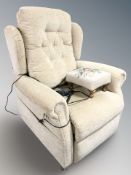 A modern electric reclining armchair and a non matching tapestry stool
