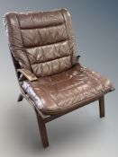 A Scandinavian stitched brown leather armchair,