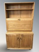 An Ercol light elm bookcase / drinks cabinet, fitted cupboards and shelves, 92 cm x 47 cm x 162 cm.
