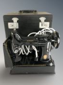 A Singer featherweight electric sewing machine in case.