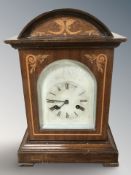 An Edwardian inlaid mahogany mantel clock, striking on a gong, with pendulum, height 38 cm.