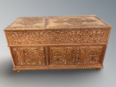 A heavily carved and stained storage box, 147 cm x 62 cm x 80 cm.