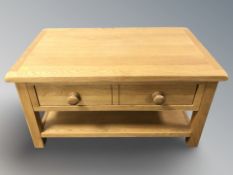 A contemporary oak two drawer coffee table / TV stand, 90 cm x 55 cm x 47 cm.