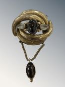 An early 19th century brooch with cabochon drop pendant and safety chain CONDITION