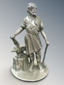 A nickel car radiator mascot, modelled as a blacksmith with anvil and hammer,