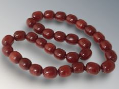 A cherry amber / Bakelite bead necklace, the oval beads each 2 cm in width,